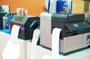 Industrial label printers with blank white label rolls on a production floor